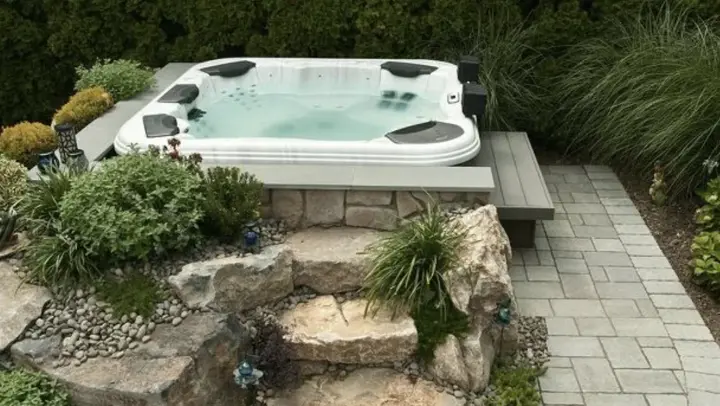 Hot tub set into a stone-faced platform with flagstone steps