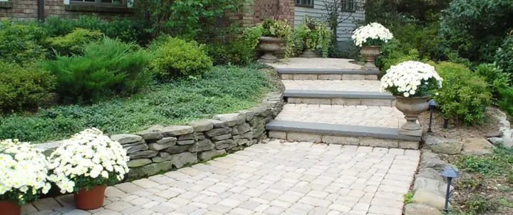 Interlocking paver walkway with steps leading to a home entrance